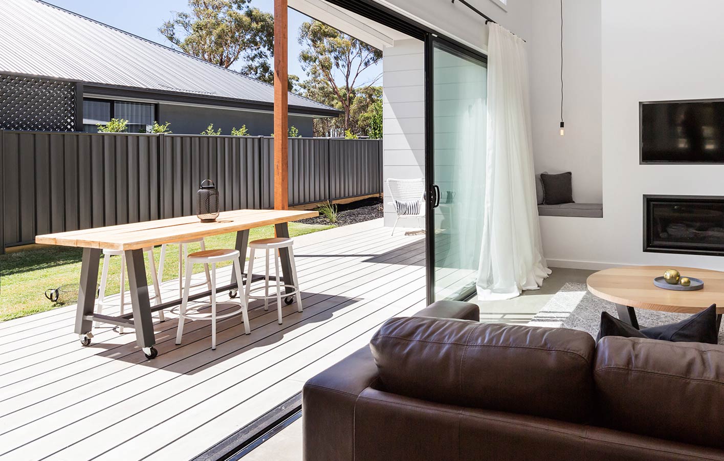 Terrassendielen für jeden Geschmack bei uns Ansicht eines Wohnzimmers mit Ausblick auf Garten mit modernem Sichtschutzzaun