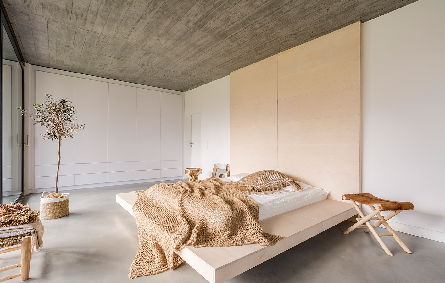Modernes Schlafzimmer mit Holzpaneelen als Kopfteil des Bettes